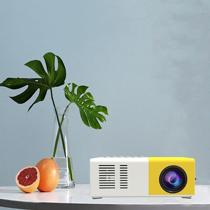 Handheld mini LED projector white-yellow, Sell My Stuff projector on table with citrus fruits on Tampa Home & Garden Store