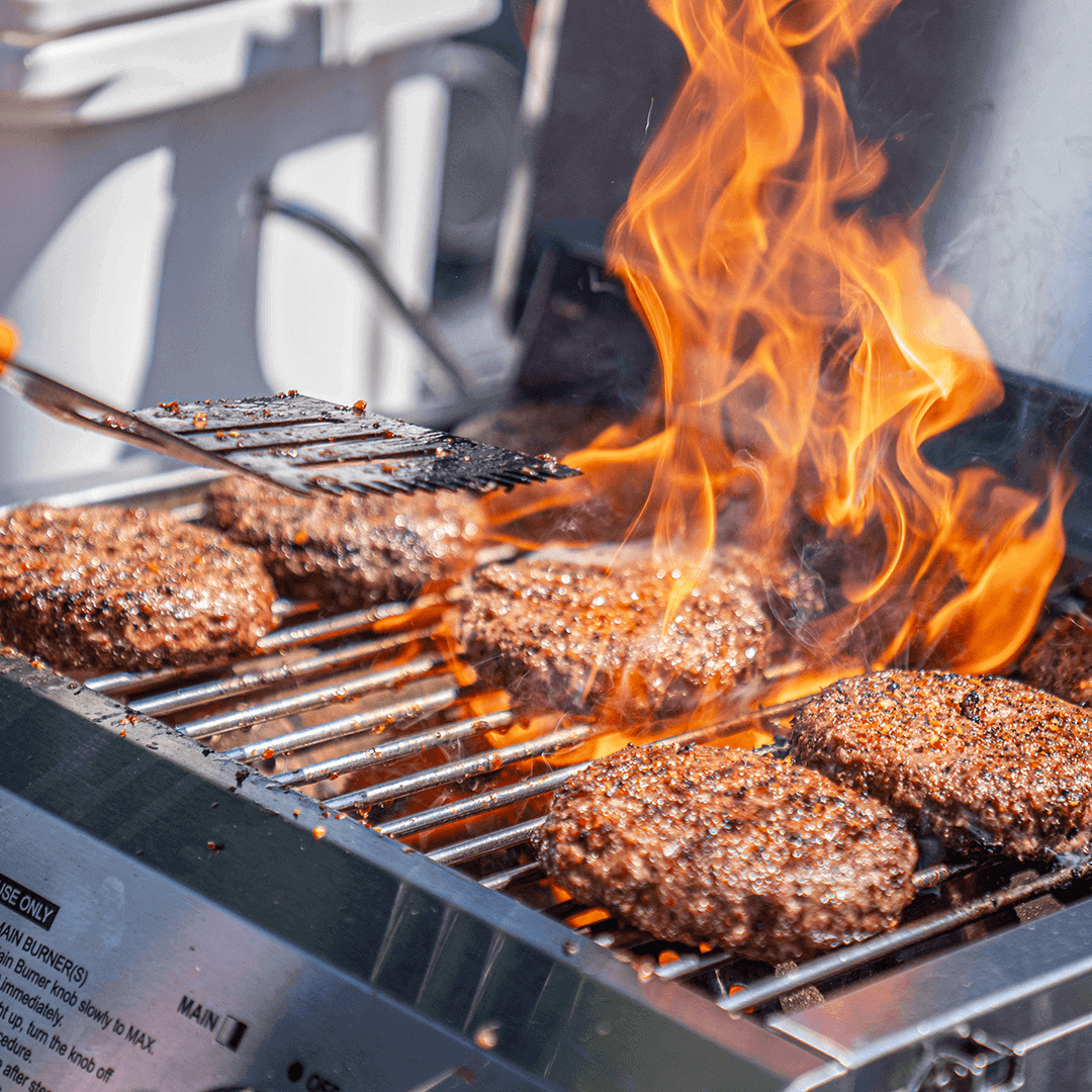 Stainless Tabletop Propane Grill with burgers on blazing flames on Tampa Home & Garden Store