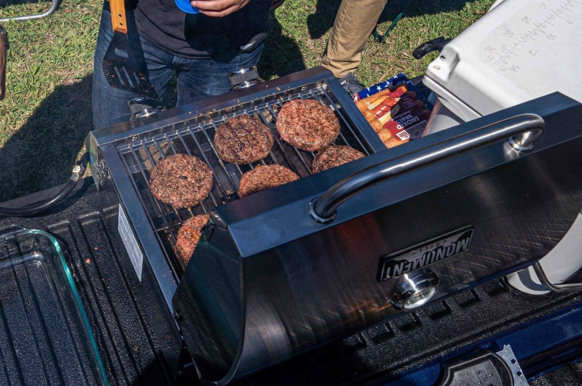Monument Grills stainless tabletop propane gas grill cooking burgers on Tampa Home & Garden Store