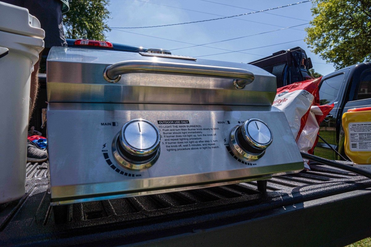 Stainless steel tabletop propane gas grill with two control knobs on a pickup bed on Tampa Home & Garden Store