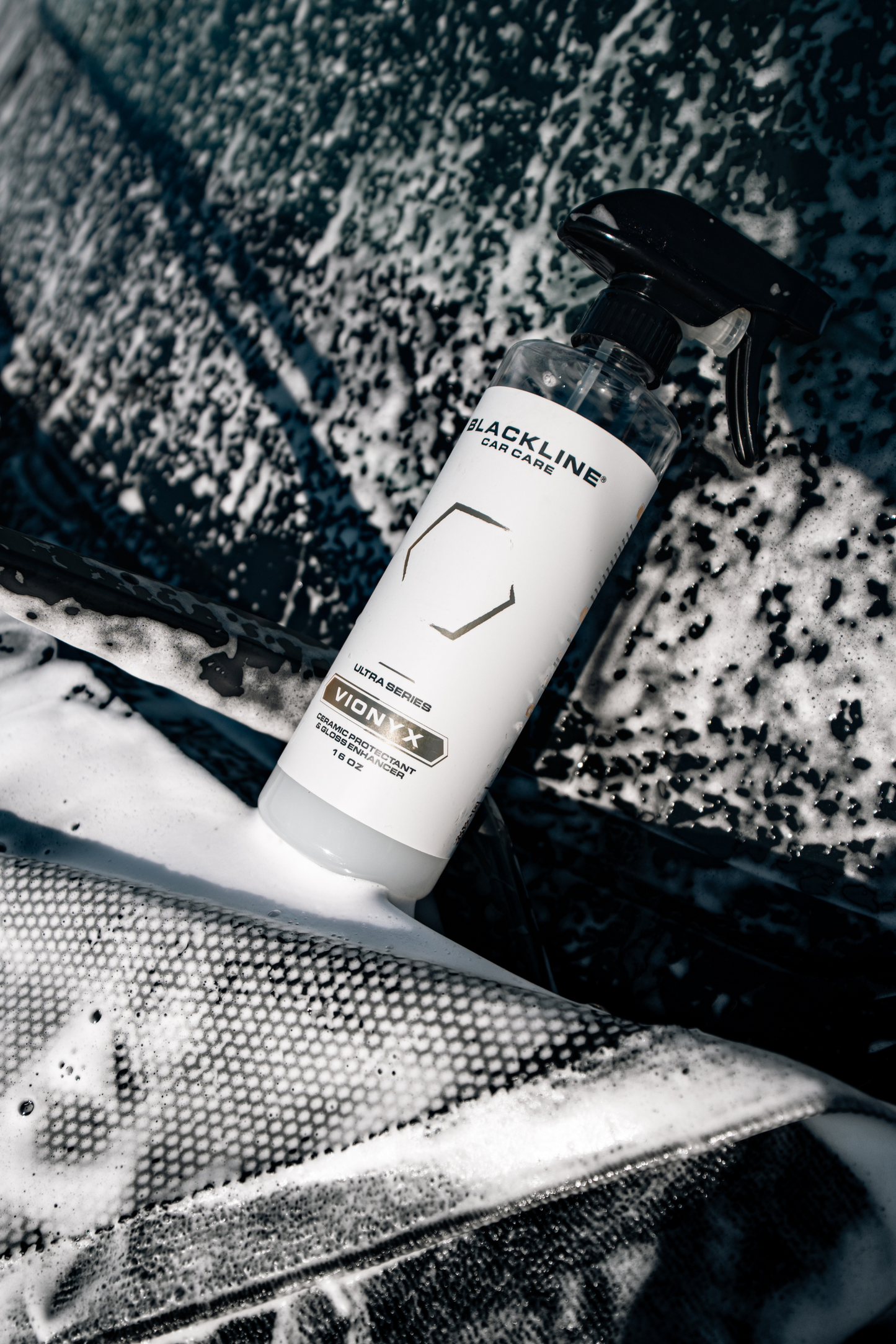 Blackline VIONYX Ceramic Protectant spray bottle with black nozzle amid car wash foam on Tampa Home & Garden Store