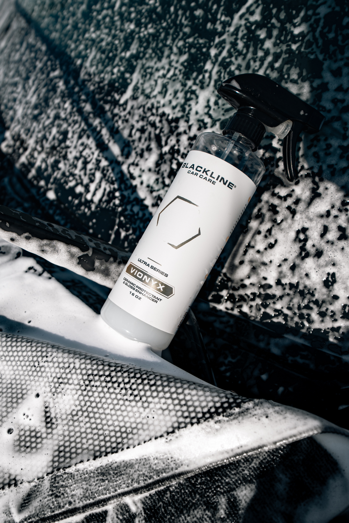 Blackline VIONYX Ceramic Protectant spray bottle with black nozzle amid car wash foam on Tampa Home & Garden Store