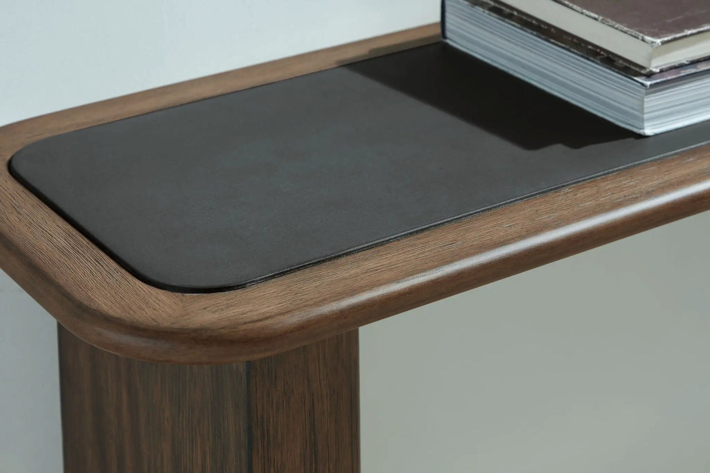 Dontayne sofa table warm brown wood with black top; stack of books on surface on Tampa Home & Garden Store
