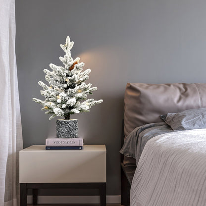 4.5ft flocked Christmas tree with LED lights in marble pot base on nightstand beside bed on Tampa Home & Garden Store