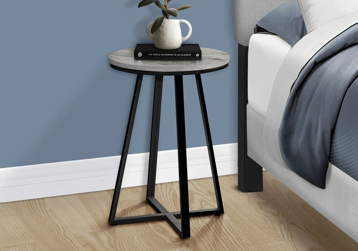 Round accent table with light wood top and black legs, white ceramic pitcher and black book on Tampa Home & Garden Store