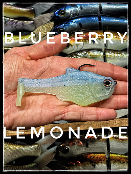 4.5in Nacho boot-tail swimbait by Bull Shad Swimbaits, blue glitter soft plastic held in hand on Tampa Home & Garden Store