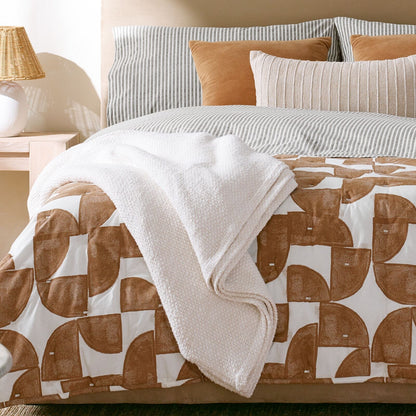 Queen Nate Berkus waffle blanket on bed with gray striped bedding and beige throw pillows on Tampa Home & Garden Store