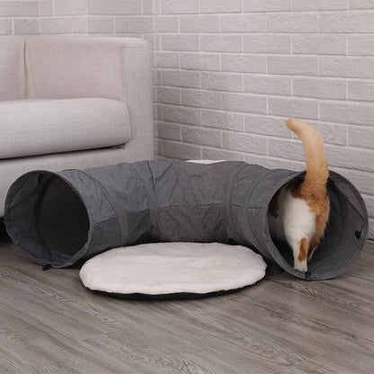 Cat tunnel in gray fabric with a white plush cushion; orange cat entering from the end on Tampa Home & Garden Store