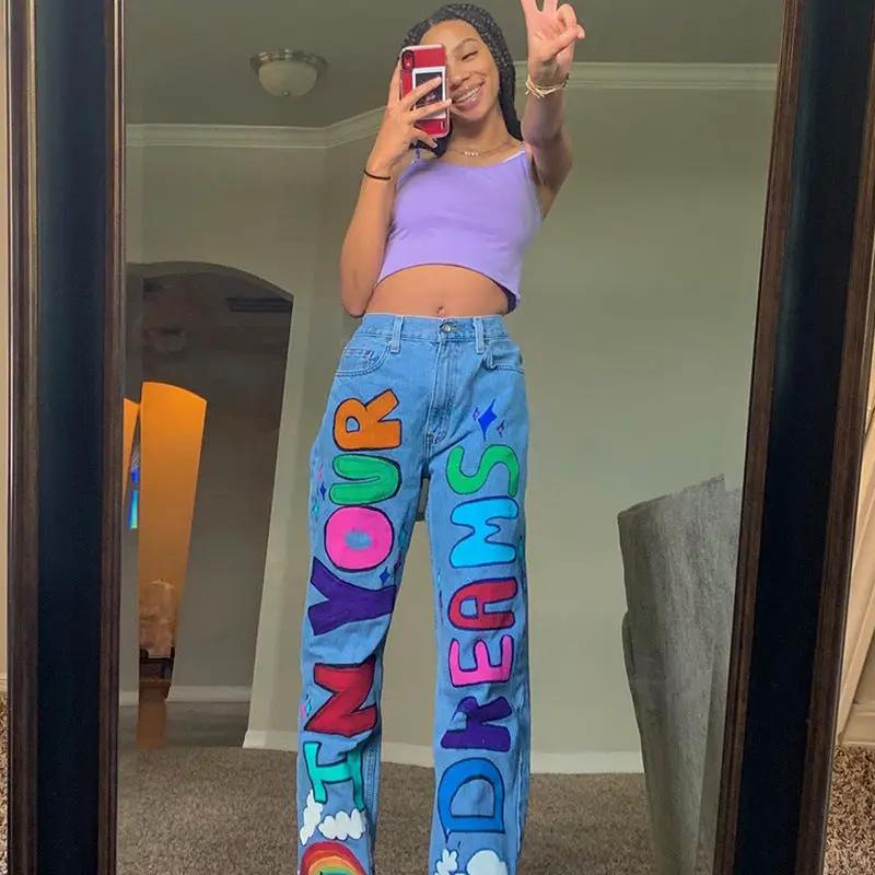 Light-blue denim jeans with bold multicolor graffiti letters on legs, loose fit on Tampa Home & Garden Store