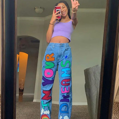 Light-blue denim jeans with bold multicolor graffiti letters on legs, loose fit on Tampa Home & Garden Store