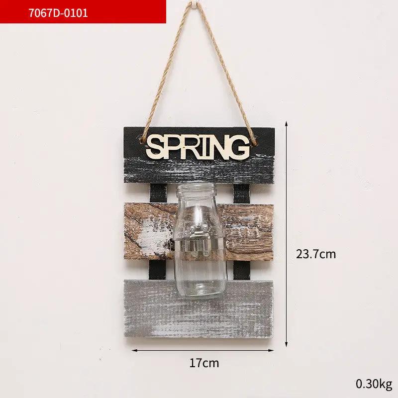 Rustic wood wall hanging with a glass bottle vase and SPRING sign on distressed planks on Tampa Home & Garden Store