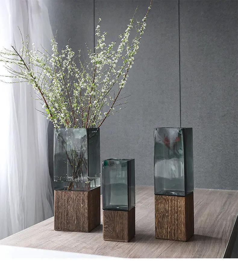 Wood color transparent glass vase set on wooden bases; three vases, left with branches on Tampa Home & Garden Store