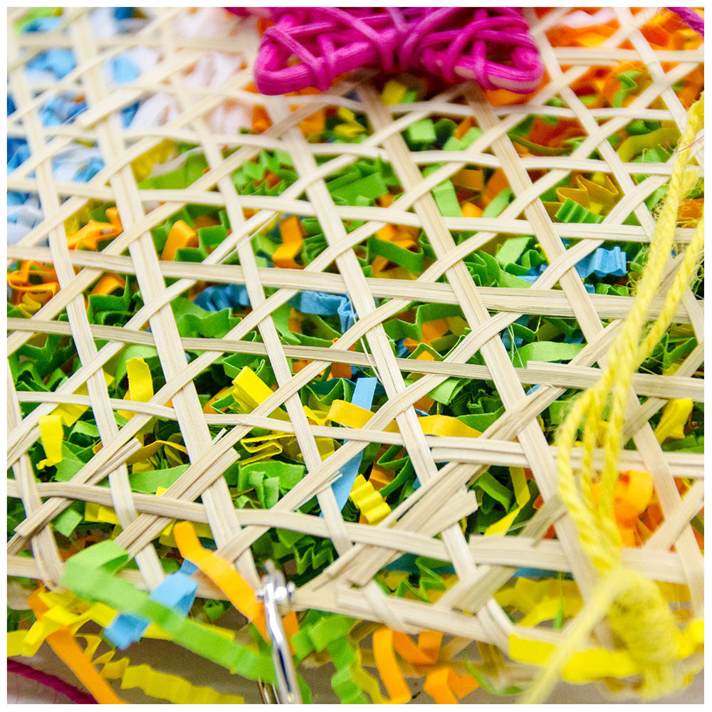 Bird brushed straw toy in a woven lattice basket with colorful shredded paper confetti and pink/yellow cords on Tampa Home & Garden Store