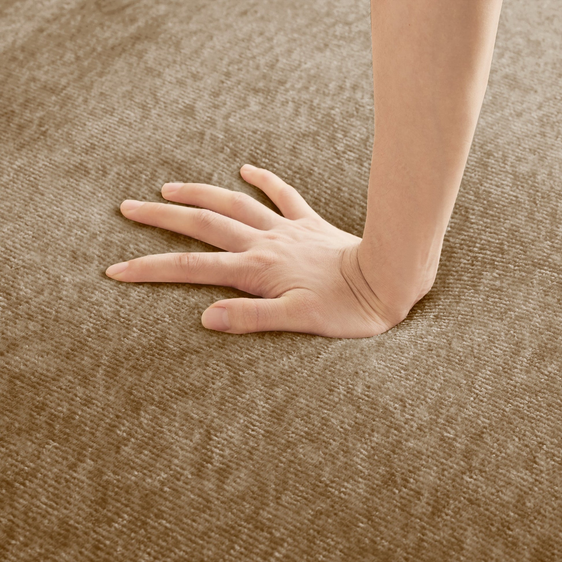 Close-up of a hand and forearm resting on a brown textured carpet on Tampa Home & Garden Store