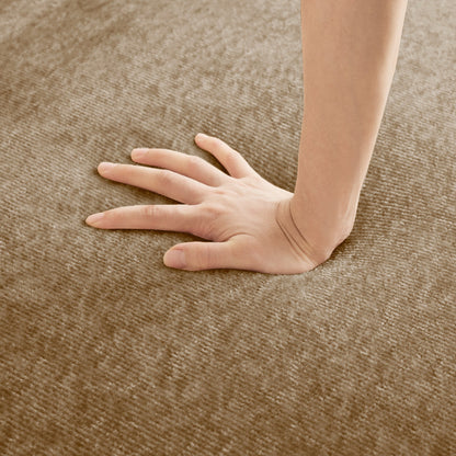 Close-up of a hand and forearm resting on a brown textured carpet on Tampa Home & Garden Store
