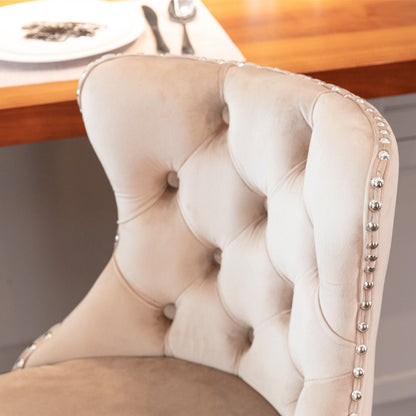 Beige tufted dining chair with silver nailhead trim along the edge on Tampa Home & Garden Store