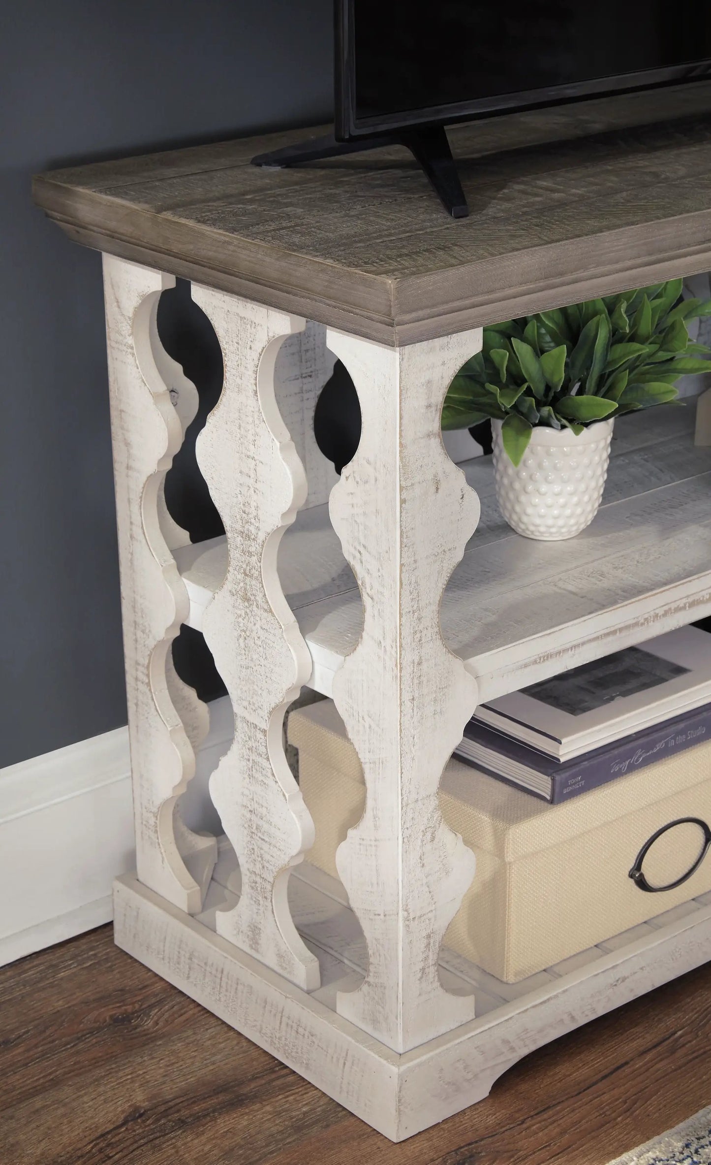 Havalance Console Sofa Table gray/white wood with carved legs; TV on top, plant on shelf on Tampa Home & Garden Store