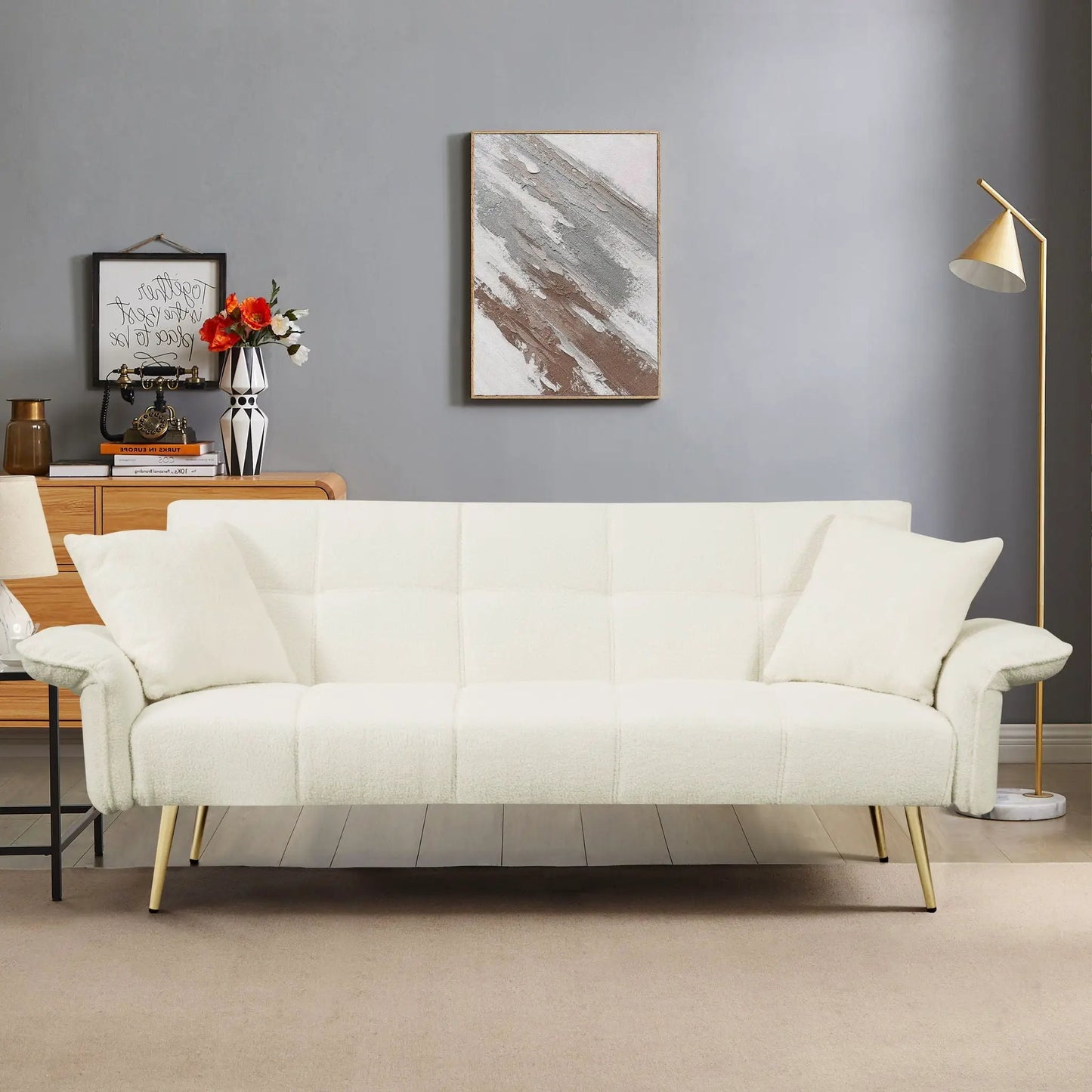 Convertible double futon sofa bed in cream fabric with slim gold legs in a modern living room setup on Tampa Home & Garden Store
