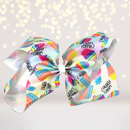 Rainbow Pop Toy hair bow & oversized sensory barrette with three colorful What’s Poppin ribbons on Tampa Home & Garden Store