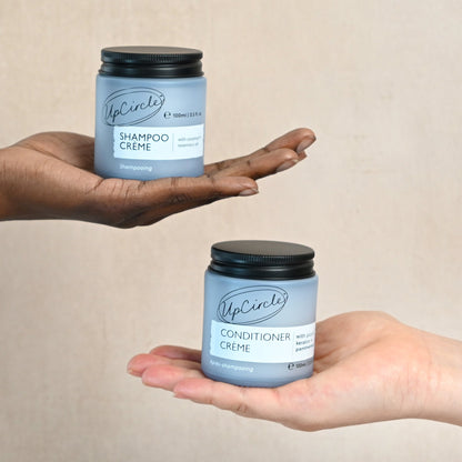 UpCircle Shampoo + Conditioner Crème duo in a blue bottle with a black cap held in hand on Tampa Home & Garden Store