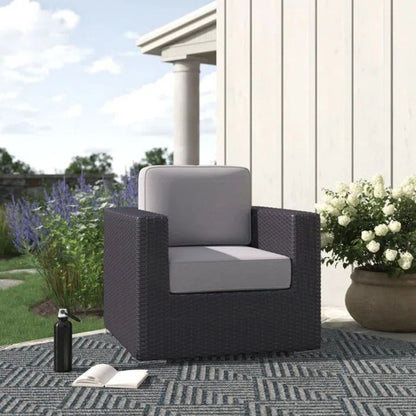 Patio arm chair with plush light gray cushions and dark wicker frame on Tampa Home & Garden Store