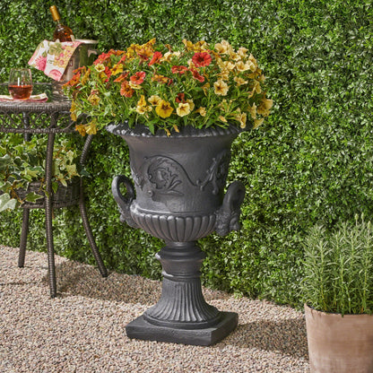 MGO Garden Urn Planter in dark gray metal filled with orange, yellow, and red petunias on Tampa Home & Garden Store
