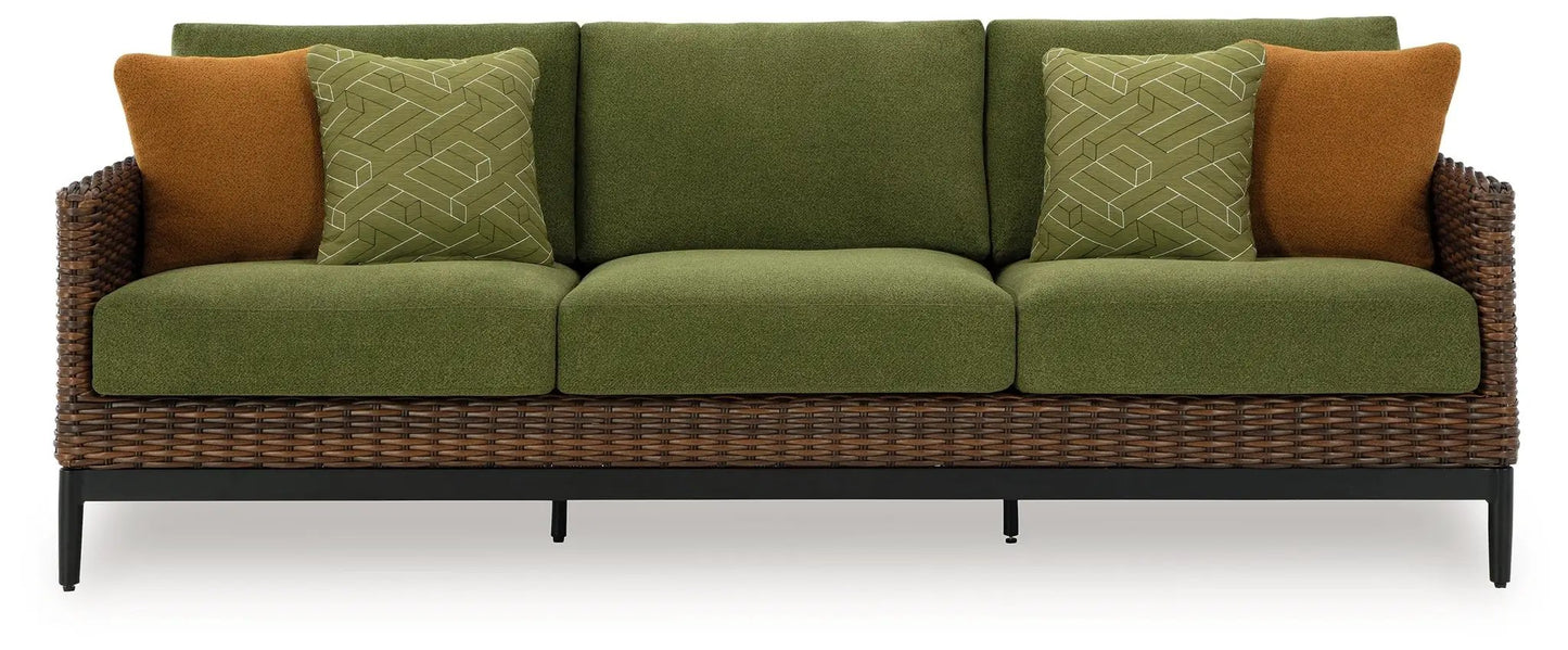 Horizon Hall sofa with green upholstery, two brown accent pillows, and wicker frame on Tampa Home & Garden Store