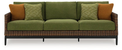 Horizon Hall sofa with green upholstery, two brown accent pillows, and wicker frame on Tampa Home & Garden Store
