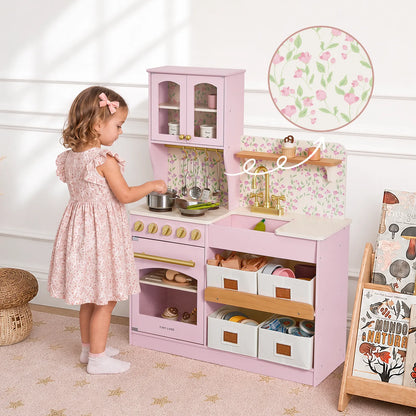 Tiny Land wooden pink play kitchen with storage, stove, and sink; child playing with pot on Tampa Home & Garden Store