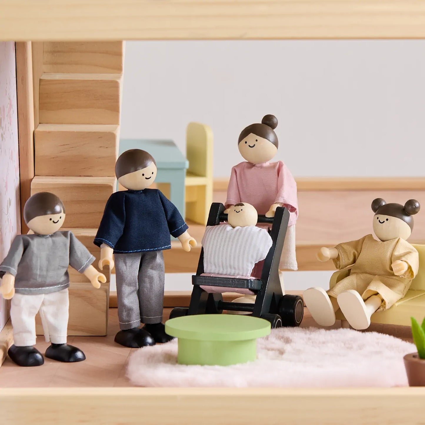 Dollhouse set by Tiny Land INC with 5 wooden dolls and a baby in stroller amid staircase on Tampa Home & Garden Store