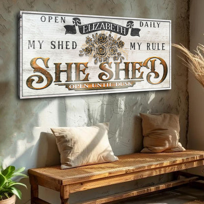 Canvas sign SHE SHED with gold lettering and bouquet on whitewash background open until dusk on Tampa Home & Garden Store