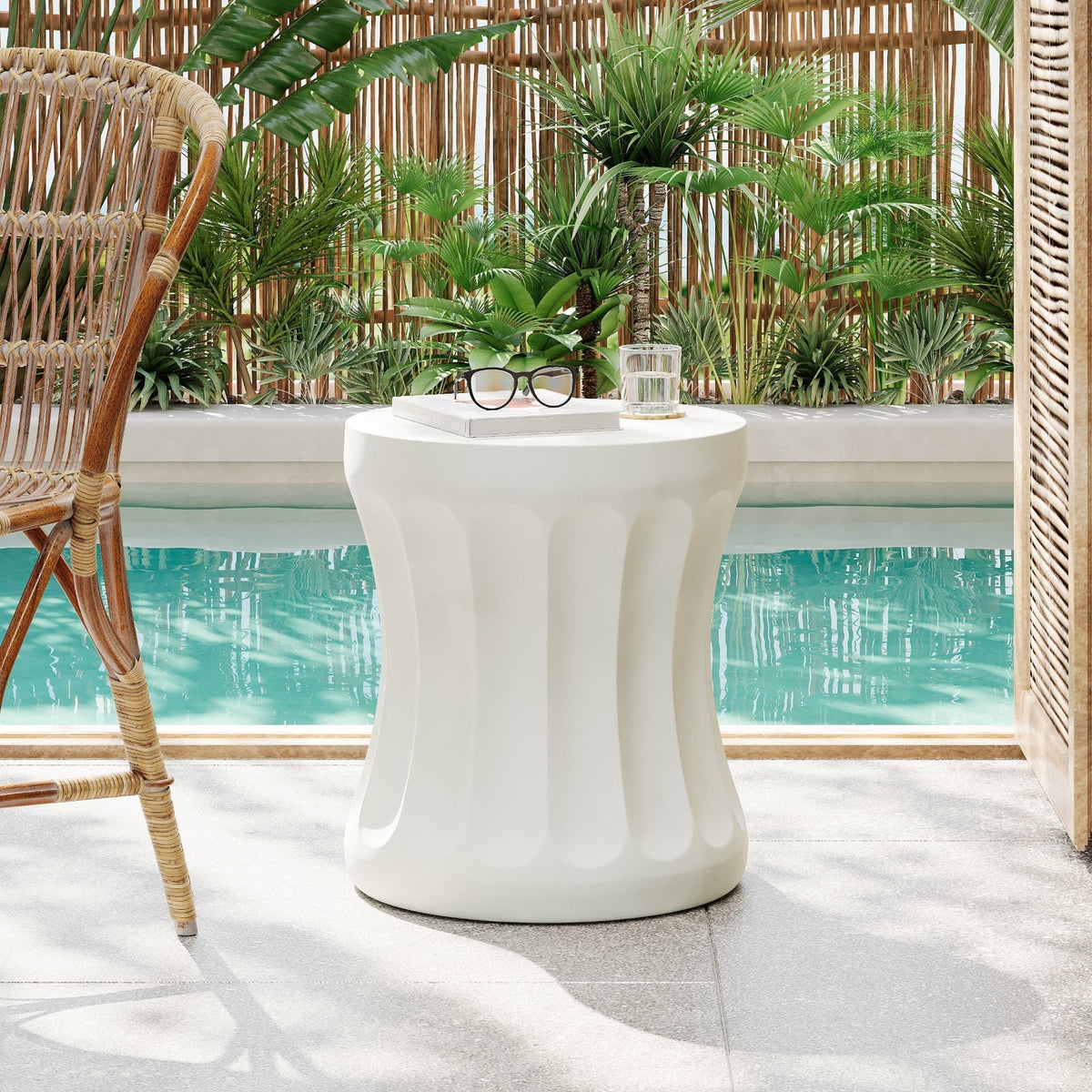 Outdoor round concrete antique white side table beside a wicker chair by the pool on Tampa Home & Garden Store