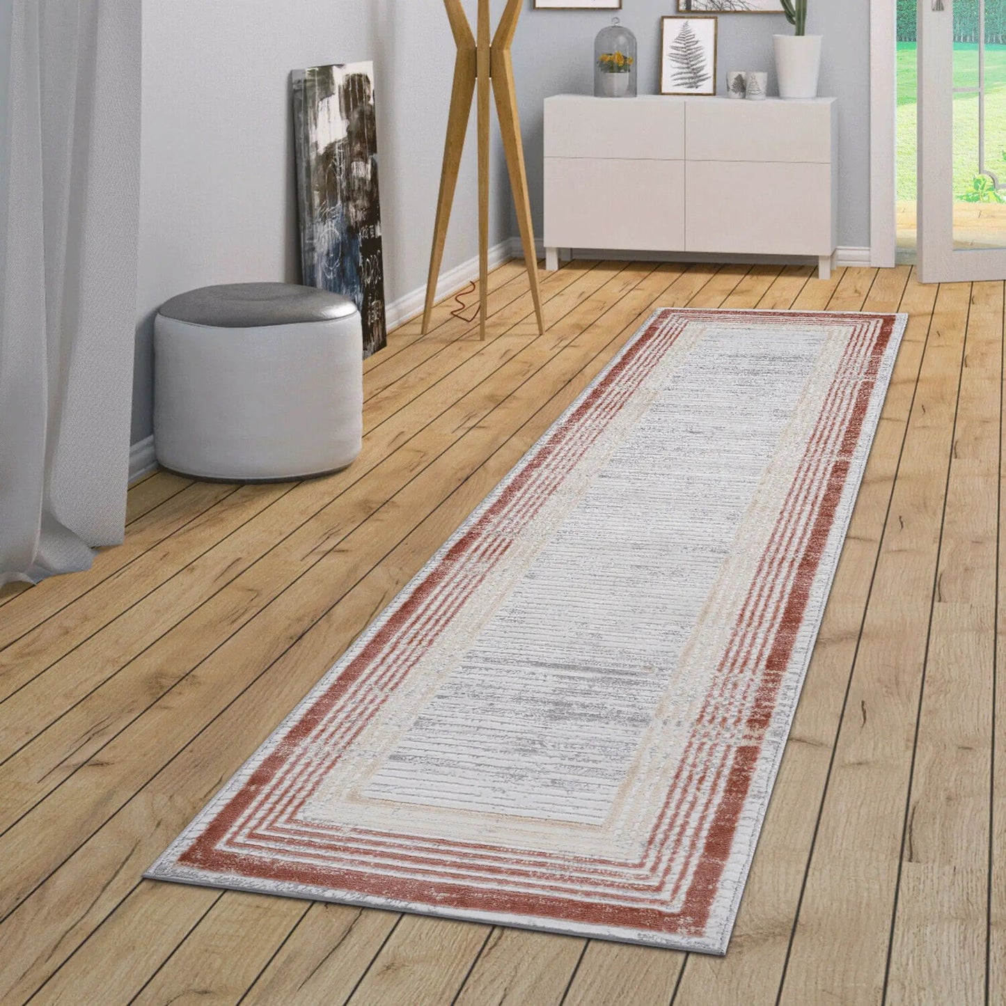 Marfi bordered area rug in light gray with rust-red nested borders on a wood floor on Tampa Home & Garden Store