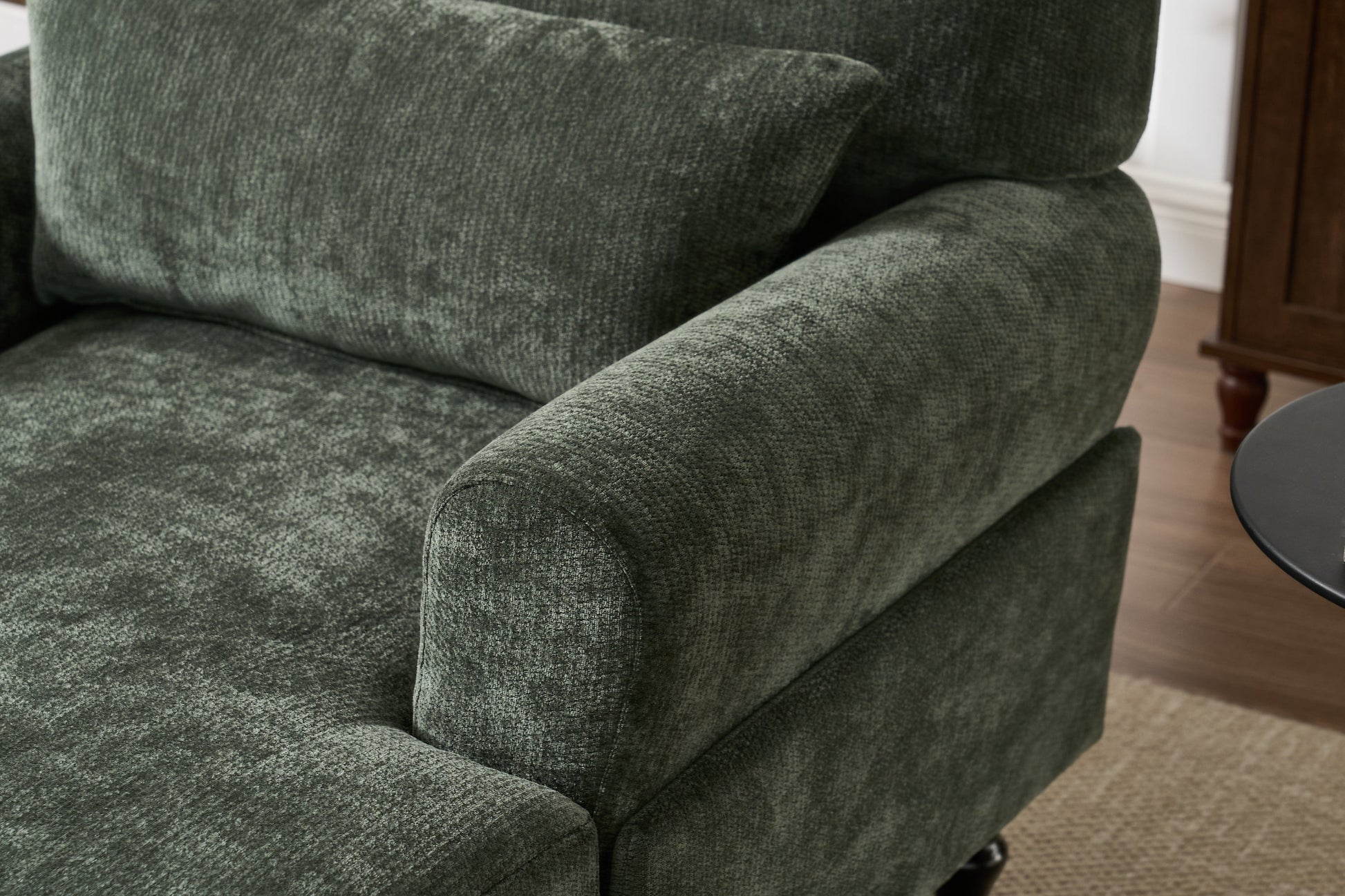 Modern green chaise lounge recliner with plush cushions and curved arm beside a side table on Tampa Home & Garden Store