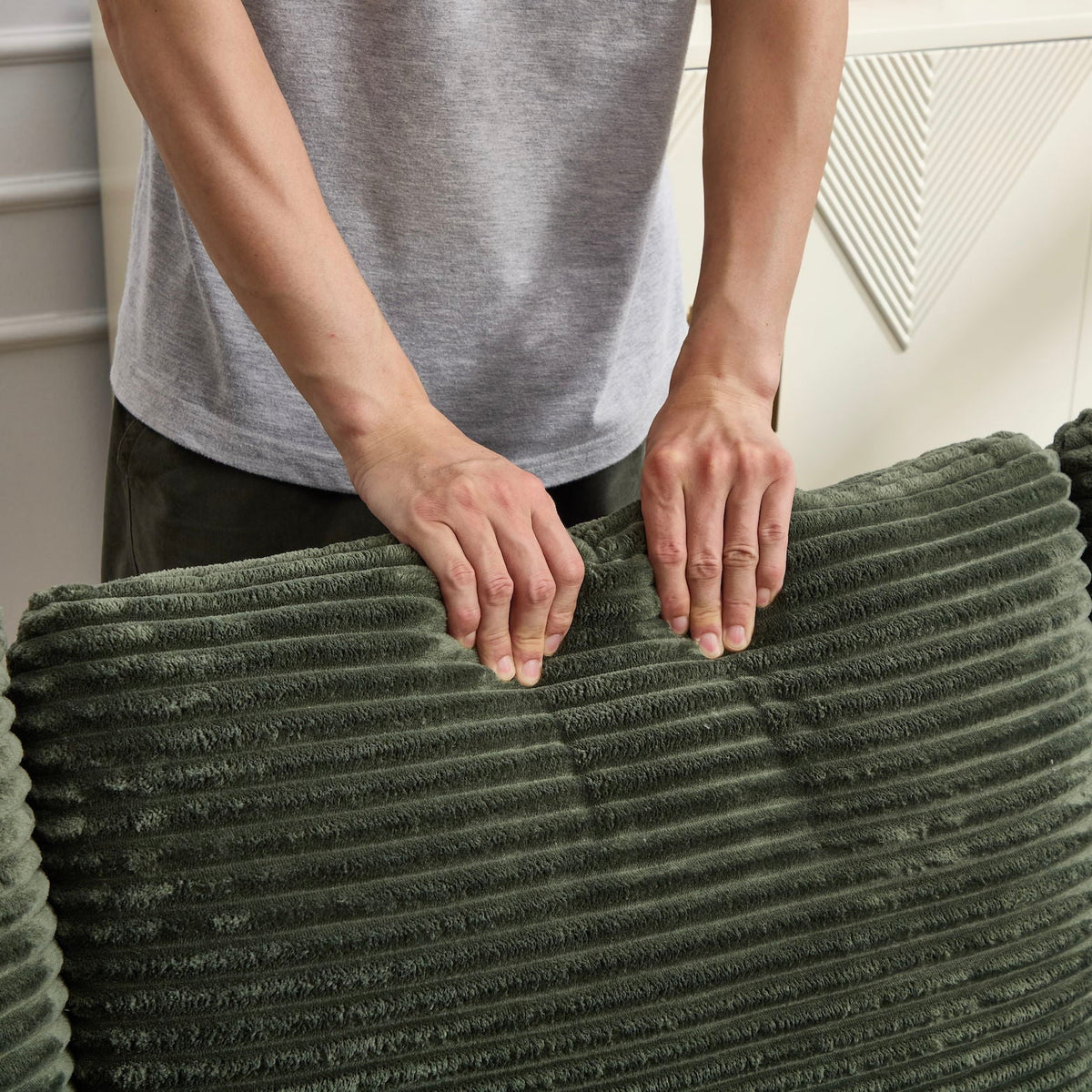 Green ribbed plush throw blanket being folded by hands on Tampa Home & Garden Store
