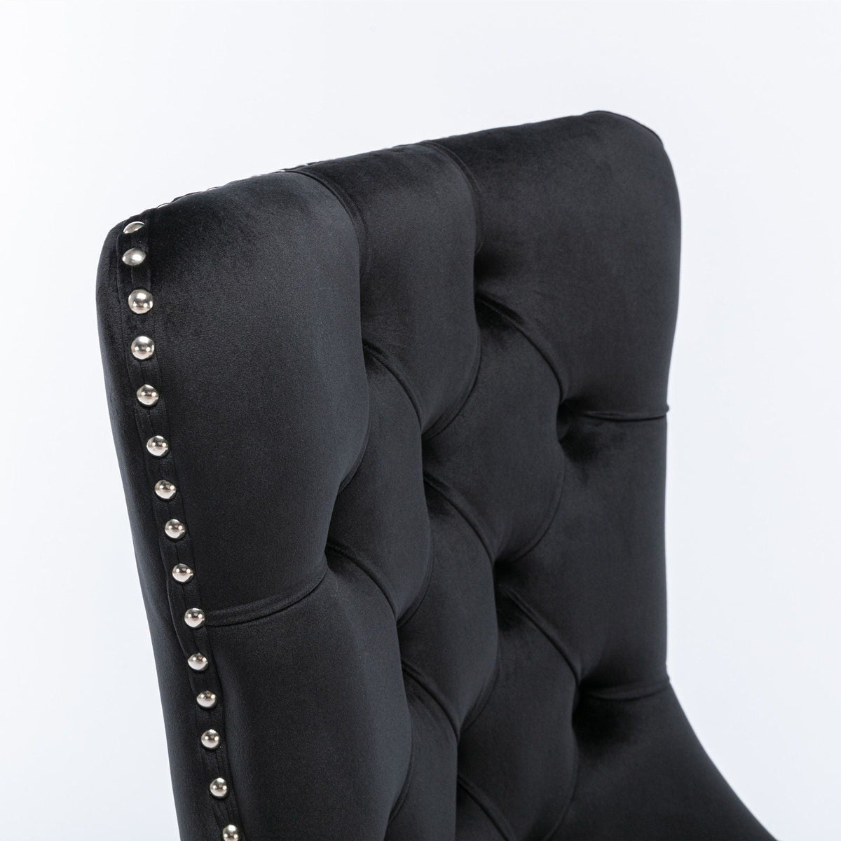 Tufted dining chair set in black velvet with silver nailhead trim along the edge on Tampa Home & Garden Store