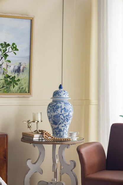 Blue and white porcelain ginger jar atop round table with bead garland and brass candle holder on Tampa Home & Garden Store