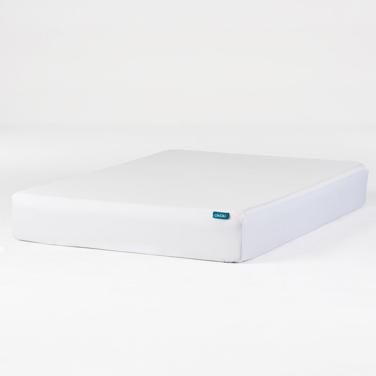 White OkiOki King Mattress Protector by HouseOfZazla on bed with blue tag on Tampa Home & Garden Store