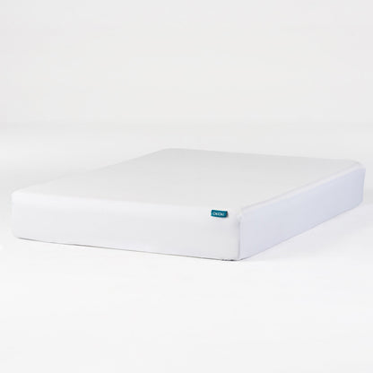 White OkiOki King Mattress Protector by HouseOfZazla on bed with blue tag on Tampa Home & Garden Store
