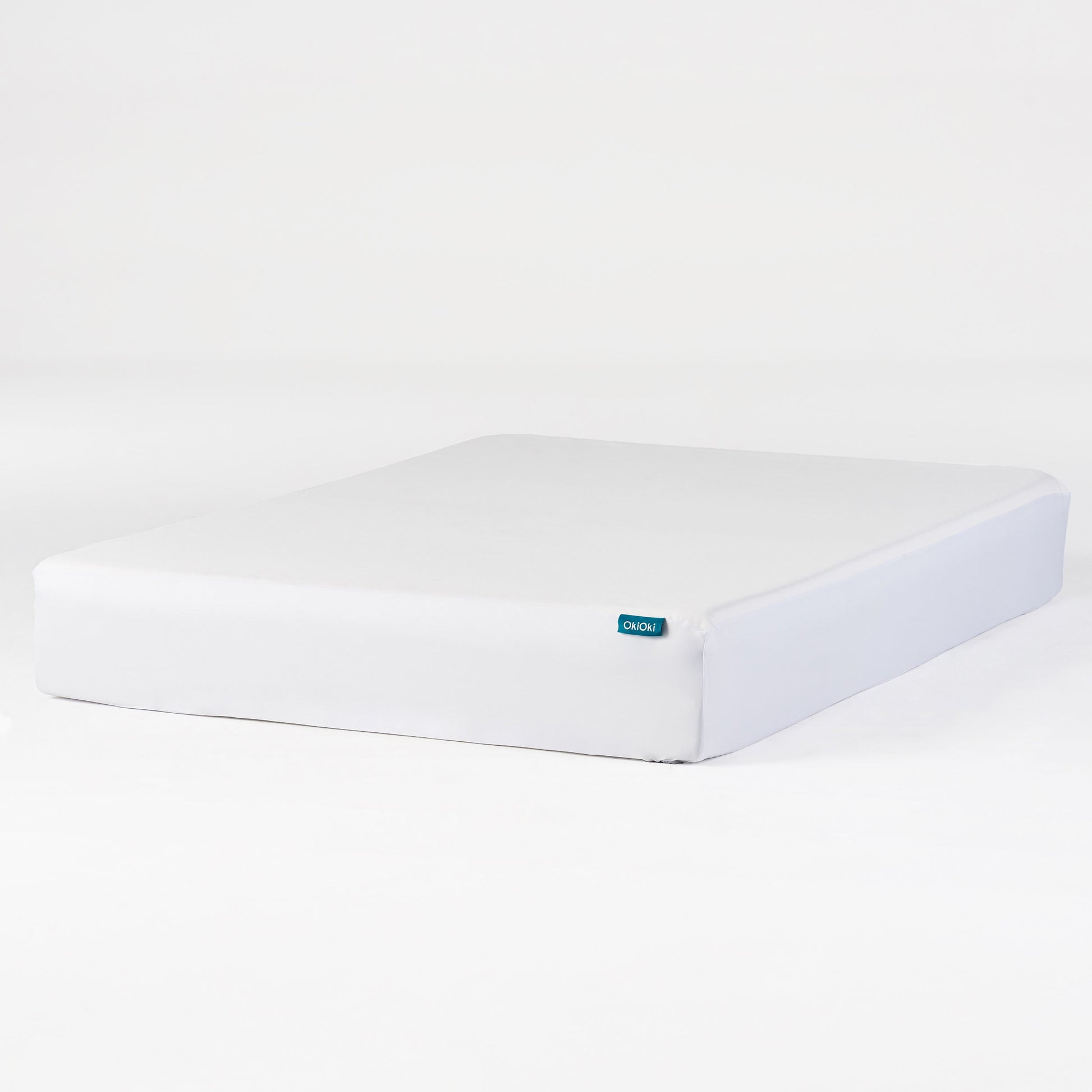 OkiOki Mattress Protector Queen white cover with teal logo tag on edge on Tampa Home & Garden Store