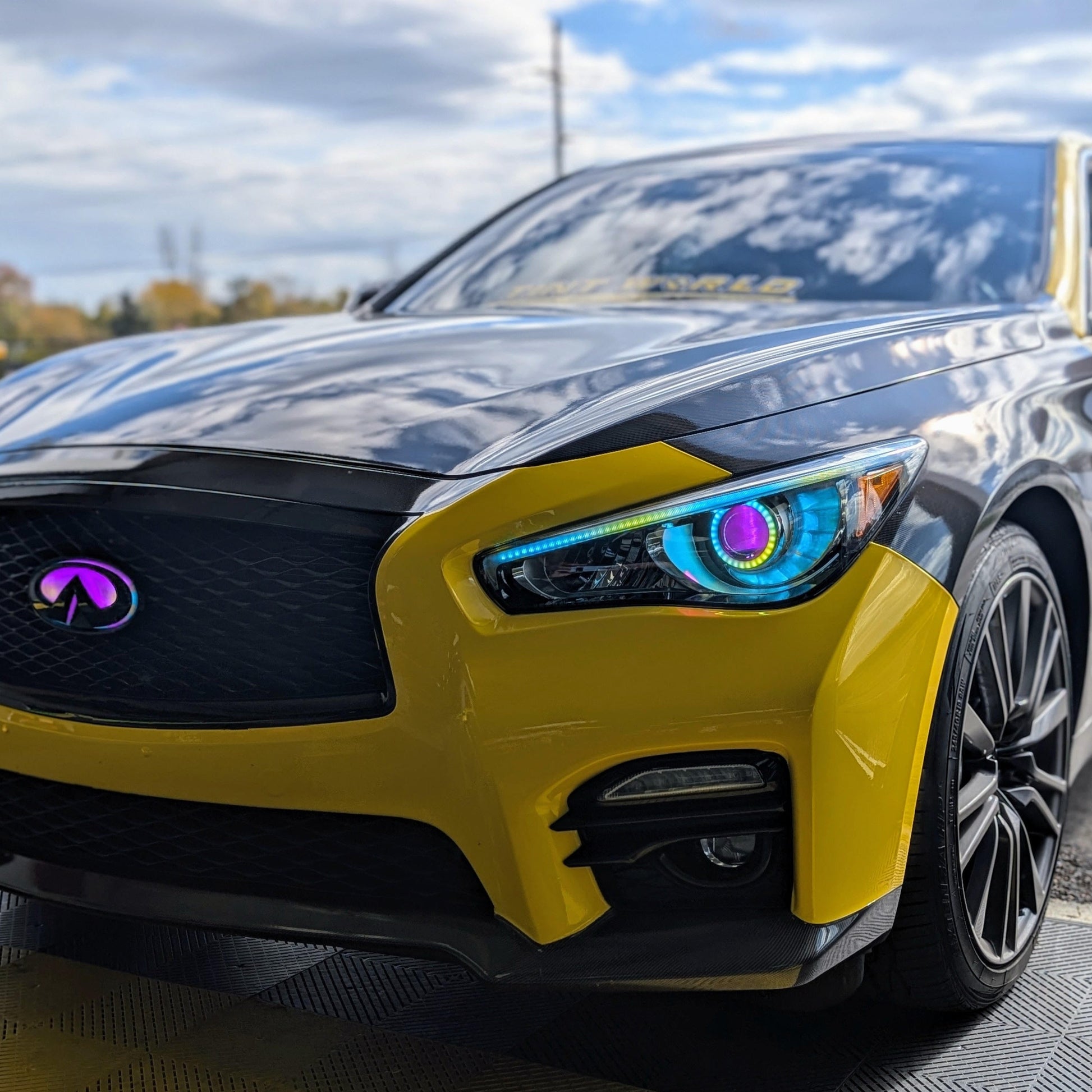 Infiniti Q50 RGBW Flow Series LED DRL boards on yellow sedan with Infiniti emblem on Tampa Home & Garden Store