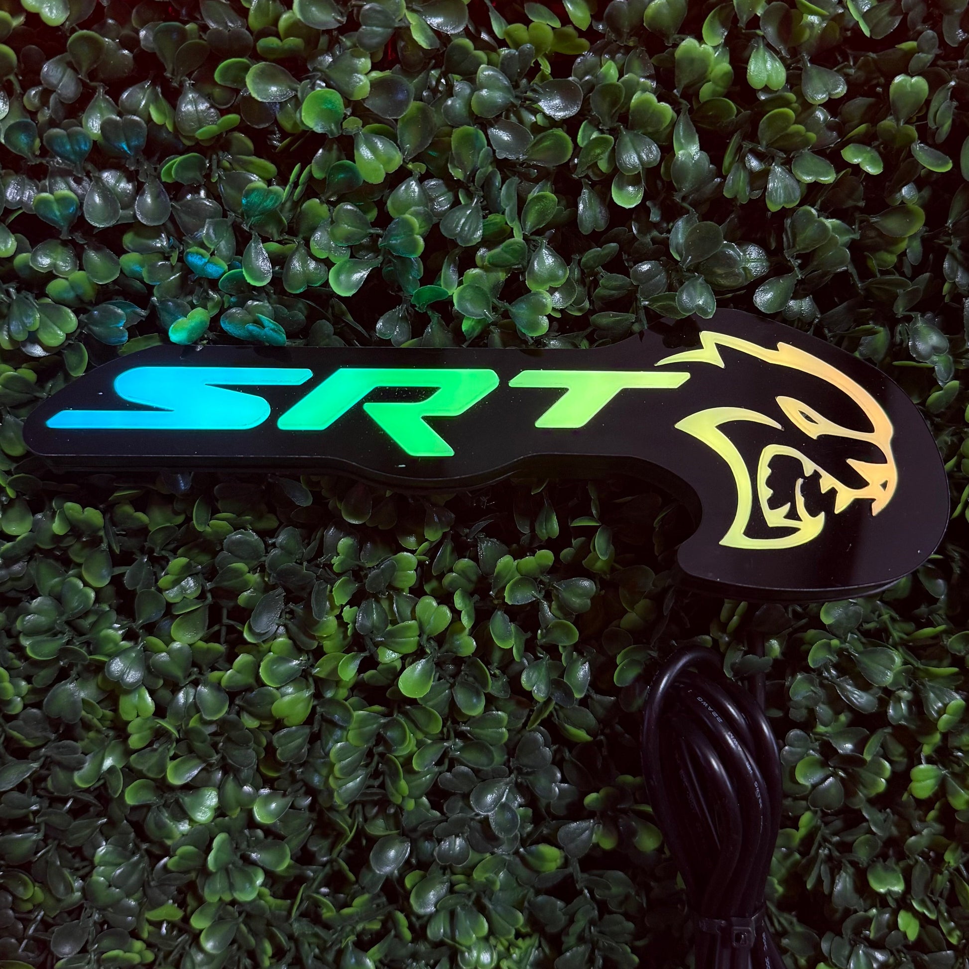 SRT Hellcat RGBW Flow Series LED badge emblem with cyan-green text and yellow logo on black panel on Tampa Home & Garden Store