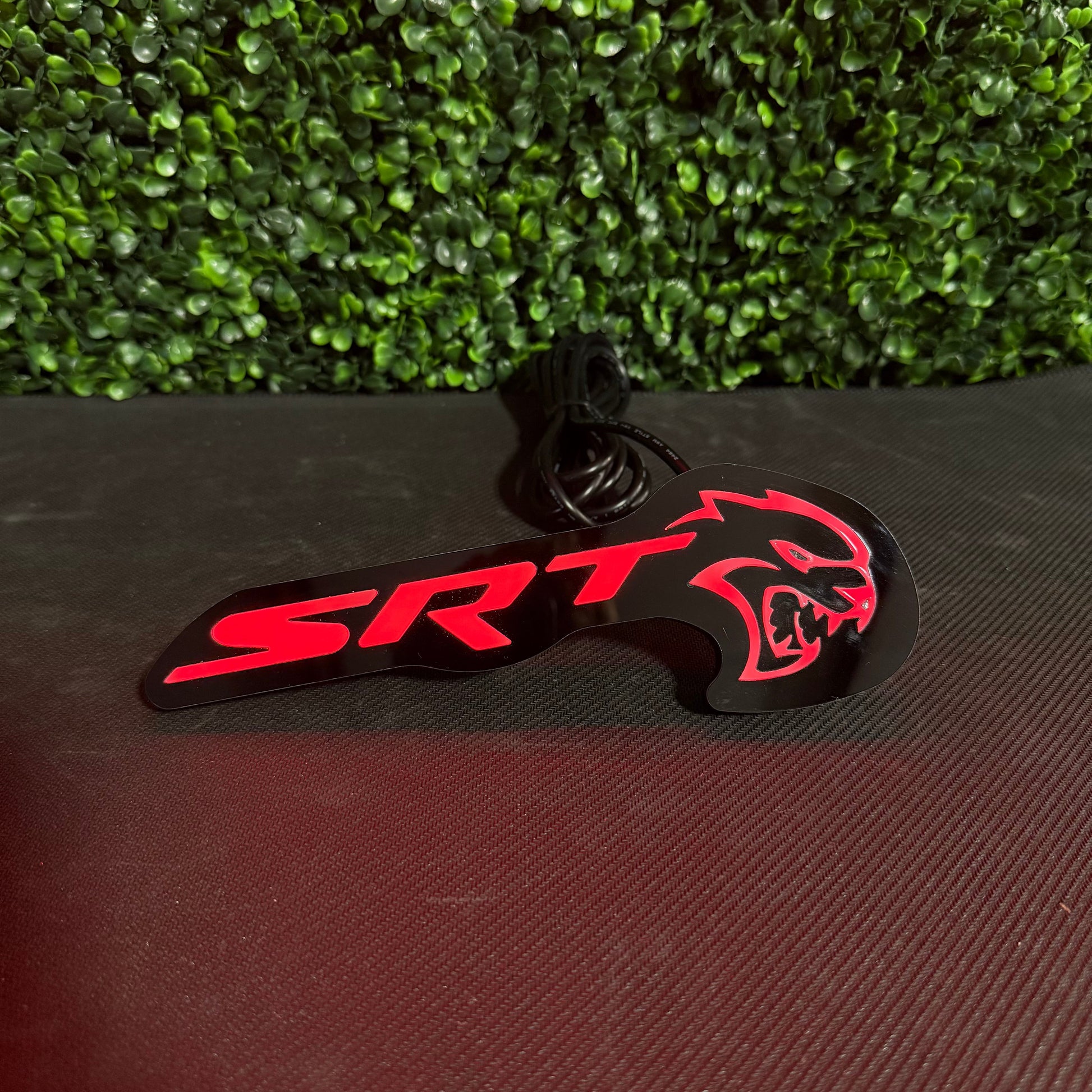 LED badge SRT Hellcat RGBW Flow; red logo on black plate with cable on Tampa Home & Garden Store