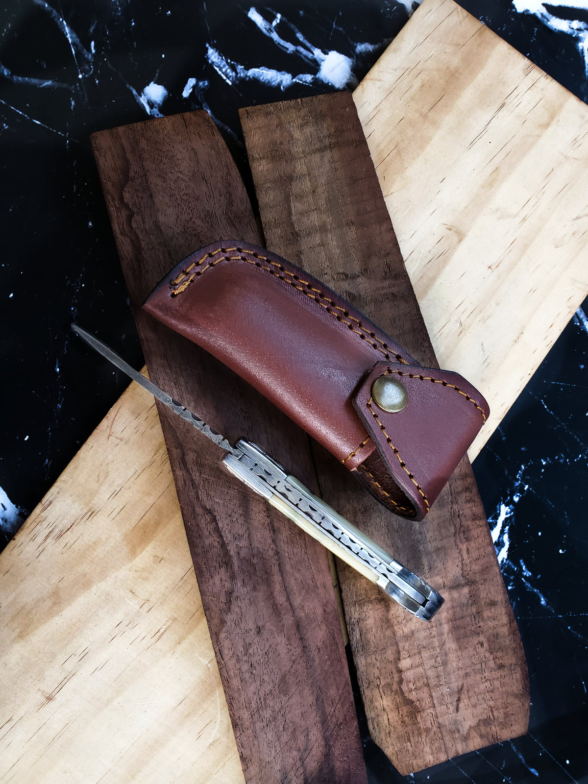 TF-005 Titan International K knife in brown leather sheath with yellow stitching on wood boards on Tampa Home & Garden Store
