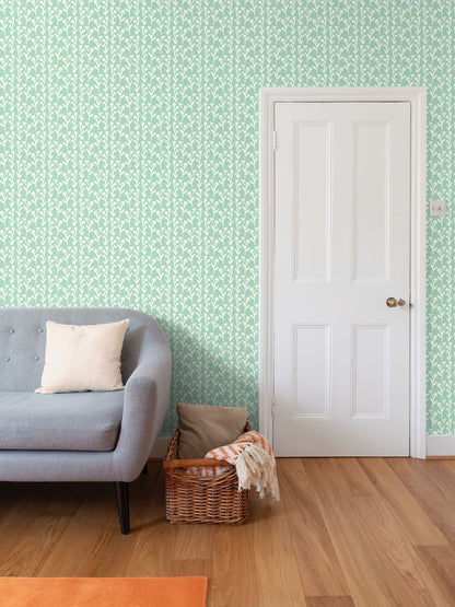 Ivy Manor Mint repeat-pattern wallpaper with white motif on mint wall beside a white door on Tampa Home & Garden Store