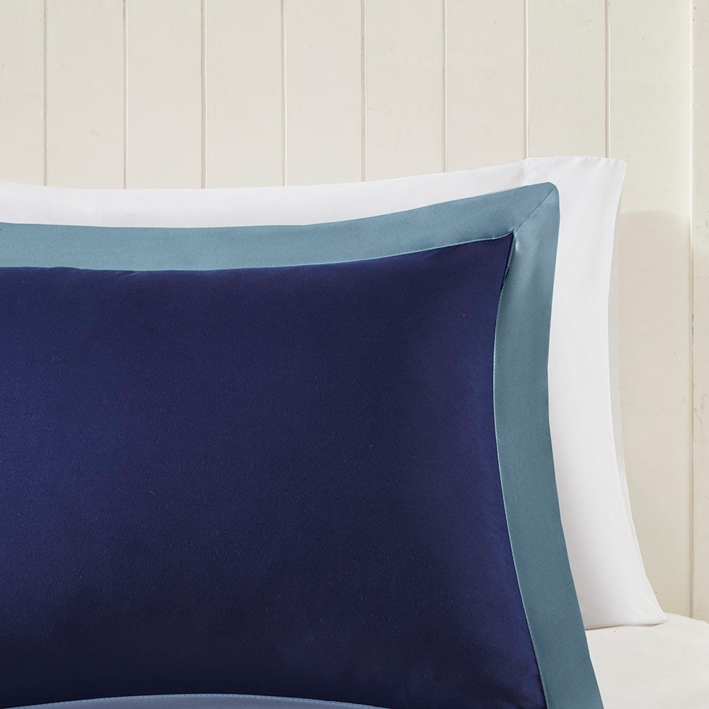 Twin/Twin XL navy decorative pillow with light blue edge on white bedding display on Tampa Home & Garden Store