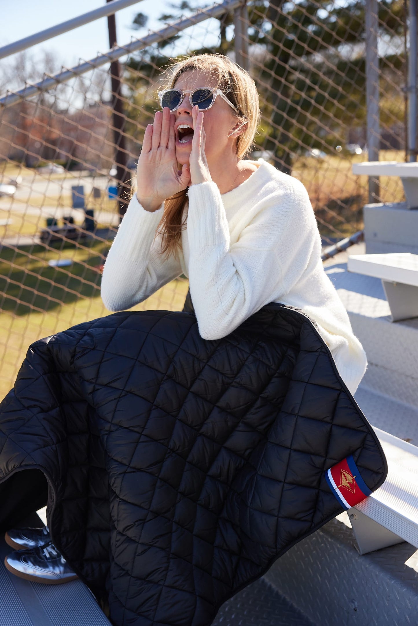 Football on Black Puffer Blanket by Pretty Rugged, quilted black outdoor blanket on bleachers on Tampa Home & Garden Store
