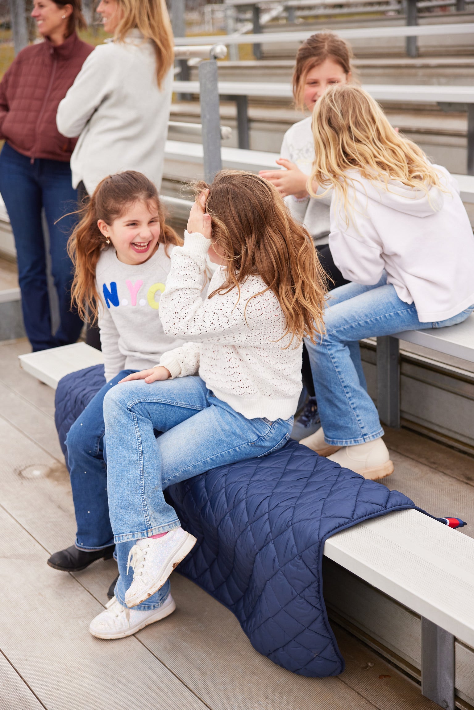 Villanova Navy Puffer Blanket by Pretty Rugged, navy quilted blanket on bleachers on Tampa Home & Garden Store