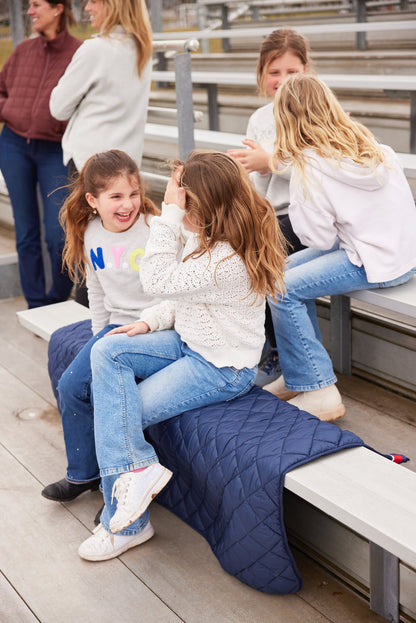 Villanova Navy Puffer Blanket by Pretty Rugged, navy quilted blanket on bleachers on Tampa Home & Garden Store