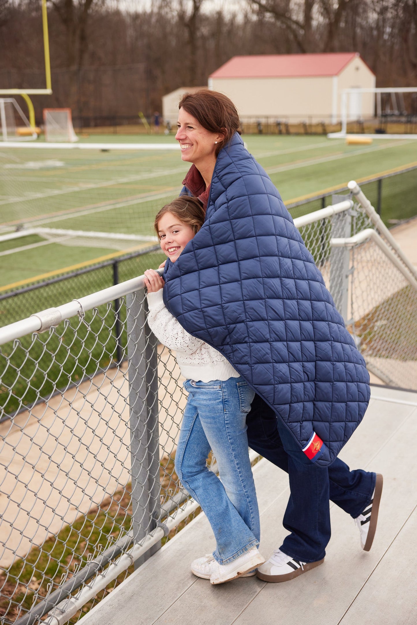 Villanova Navy Puffer Blanket by Pretty Rugged, navy quilted throw draped over railing on Tampa Home & Garden Store